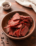 Slices of BBQ Beef Jerky piled in a round wooden bowl