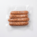 Four Bacon Cheddar Onion Smokies (Frozen) in a clear plastic vacuum-sealed bag
