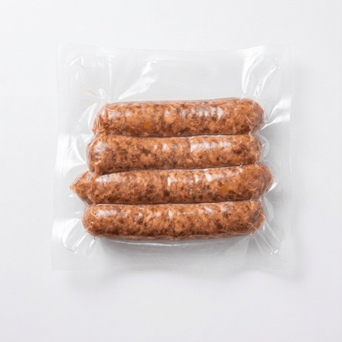 Four Bacon Cheddar Onion Smokies (Frozen) in a clear plastic vacuum-sealed bag