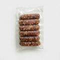 Six raw sausages in a clear vacuum-sealed plastic package