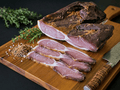 Sliced Black Forest Schinkenspeck arranged on a wooden cutting board