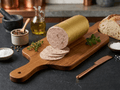 A sliced log of Coarse Liver Sausage on a wooden cutting board