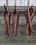 Landjäeger Sausages hanging from metal hooks