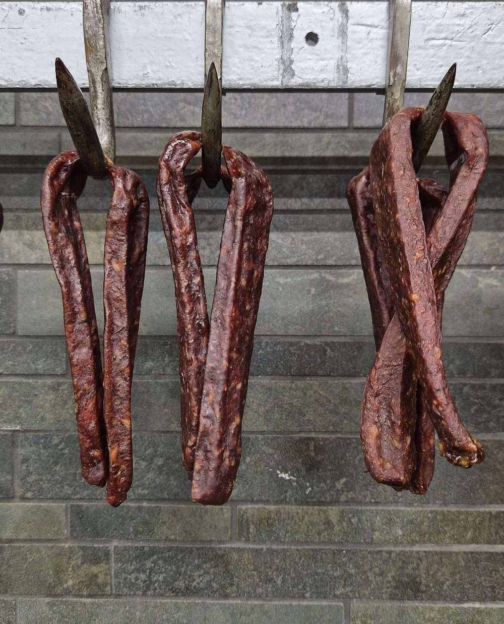 Landjäeger Sausages hanging from metal hooks