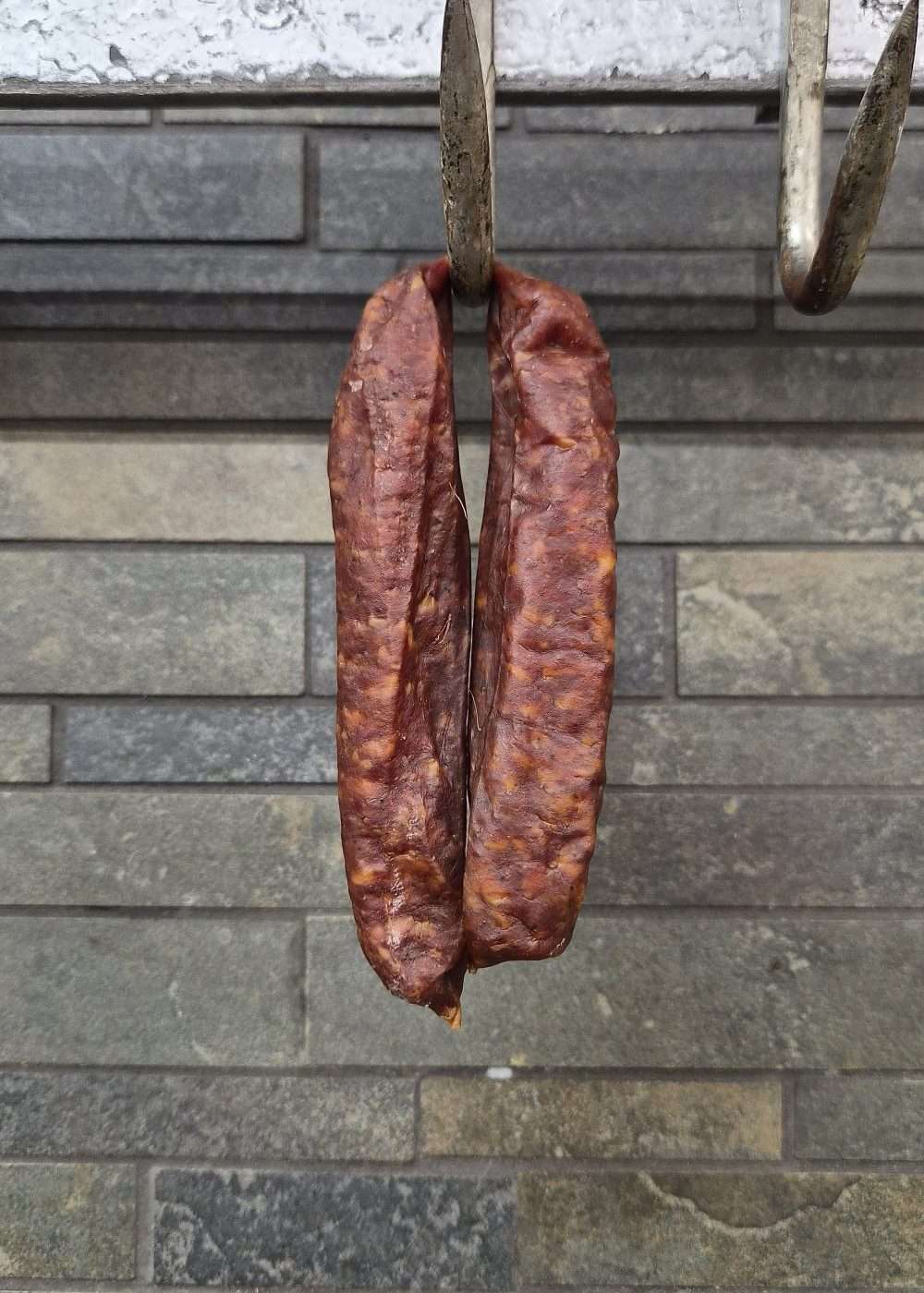 Two Westfalian Smokies hanging from metal hooks